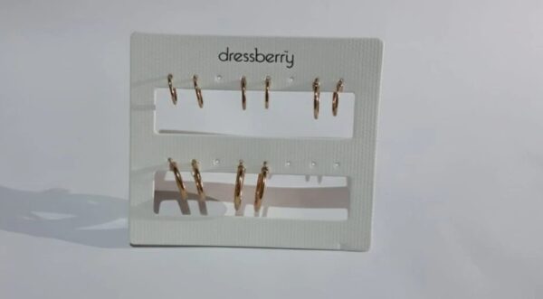 Gold hoop earring collection on black display stand